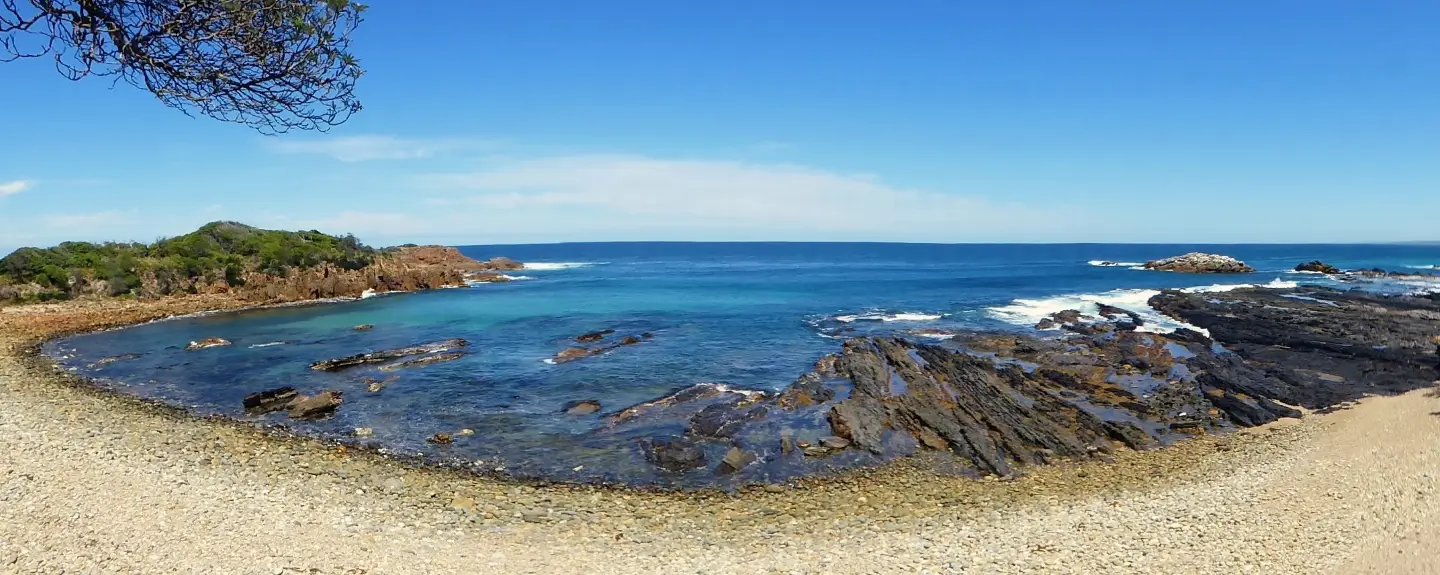 a view of a beach at low tide with a curved lens